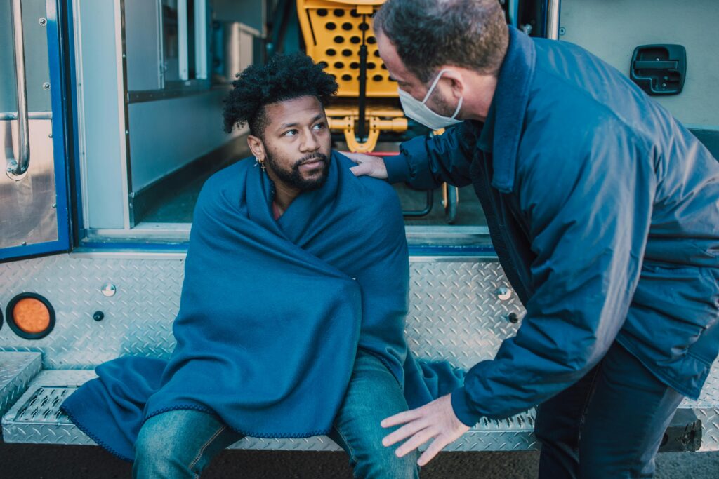 A person receiving help from emergency services, showing a situation where knowing key phrases can be important in Prague