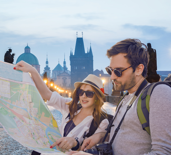 Travelers in Prague using Czech phrases while navigating the city with a map