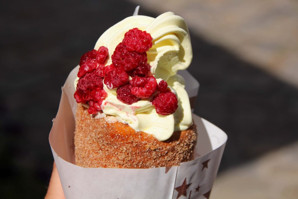 Trdelník (chimney cake) filled with cream and raspberries – popular street dessert in Prague Food Guide