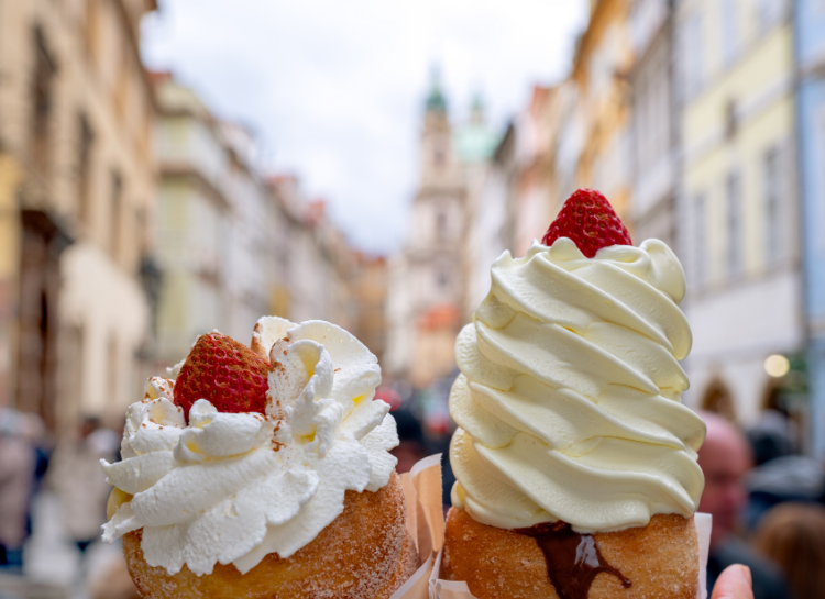 Traditional Czech trdelník dessert topped with whipped cream and strawberries in Old Town Prague – Prague Food Guide