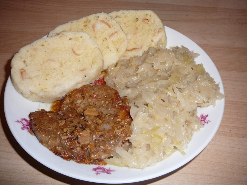 Vepřo knedlo zelo with roast pork, bread dumplings, and sauerkraut – traditional Czech dish featured in Prague Food Guide