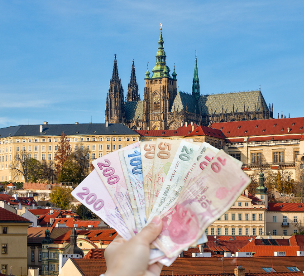 Prague trip cost concept with Euros banknotes and Prague Castle in the background