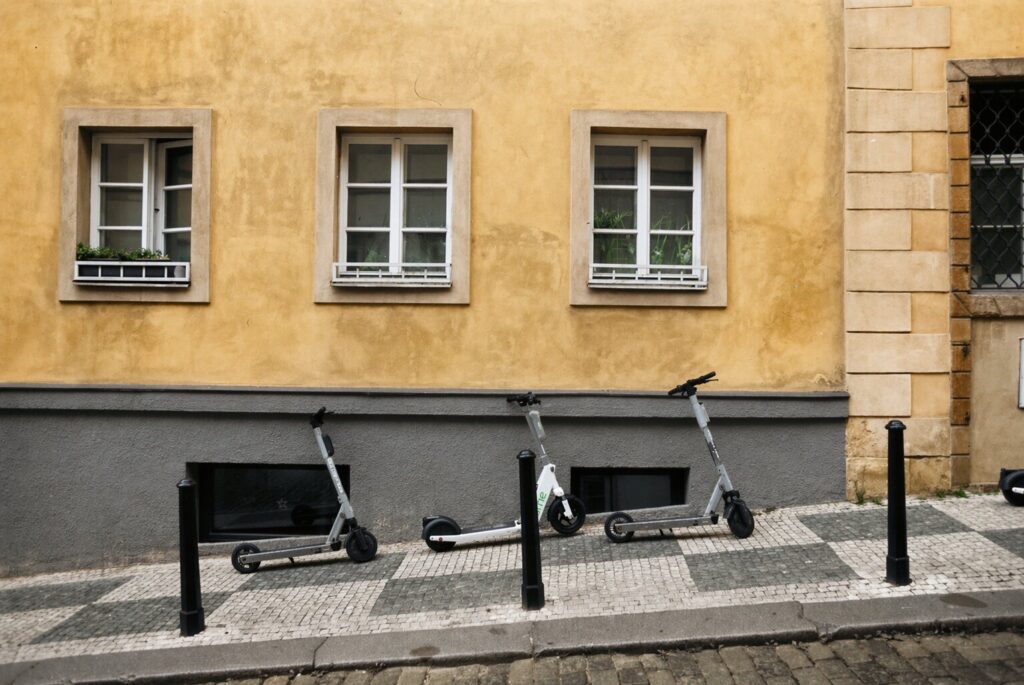Electric scooters parked on a sidewalk in a Prague street