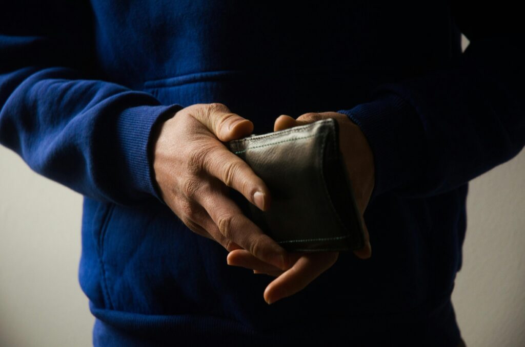 Person holding a wallet securely with both hands to prevent theft