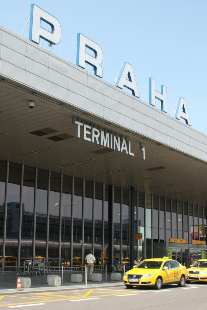 Prague Airport Terminal 1 exterior with PRG sign and taxi area