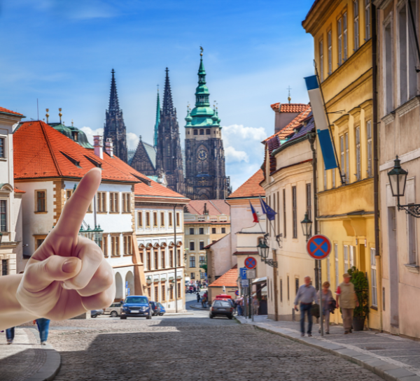 Things to avoid in Prague shown through a scenic street with historic buildings and Prague Castle in the background