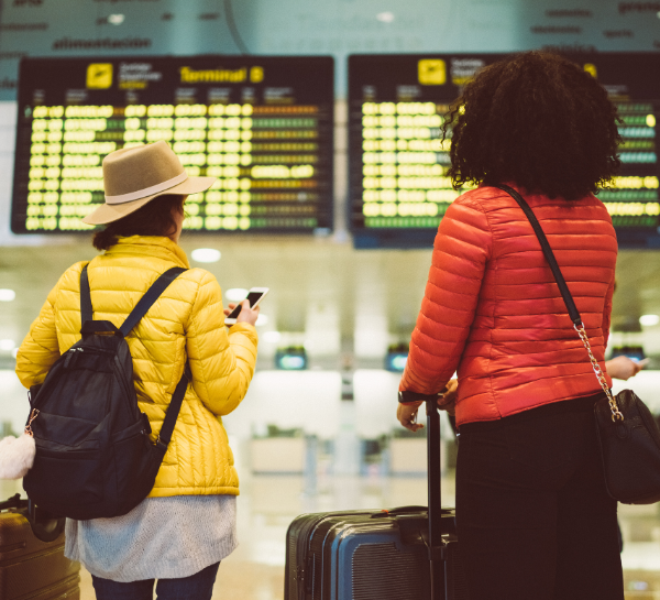 Travelers checking flight information with luggage at Václav Havel Airport Prague arrivals hall
