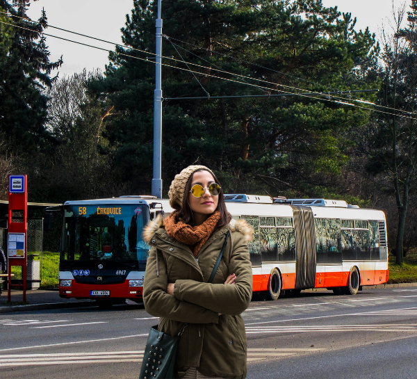 Tourist standing near Prague Buses 2026 public transport bus stop in Prague during winter travel