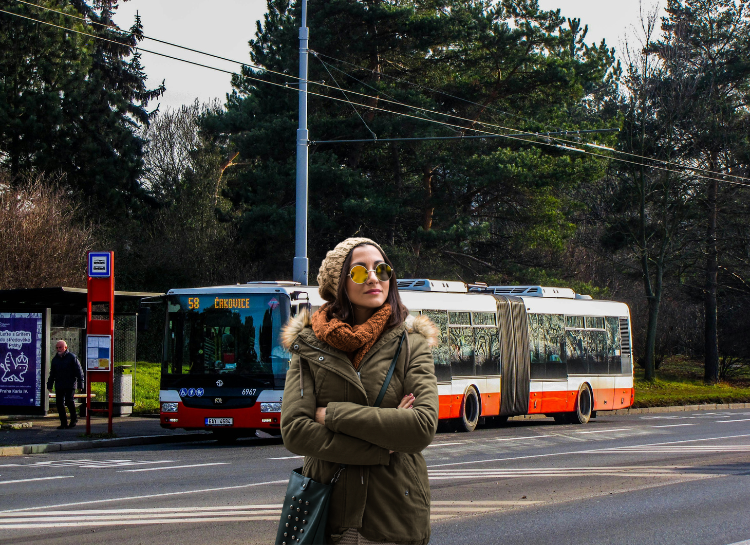 Tourist standing near Prague Buses 2026 public transport bus stop in Prague during winter travel