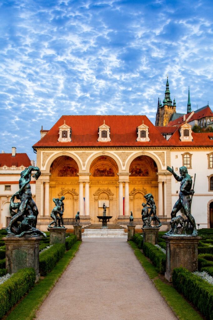 Wallenstein Palace Garden in Prague with Baroque statues and historic Prague Palaces architecture at sunset