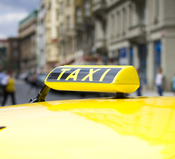 Yellow Prague taxi sign on top of a taxi car in Prague city center