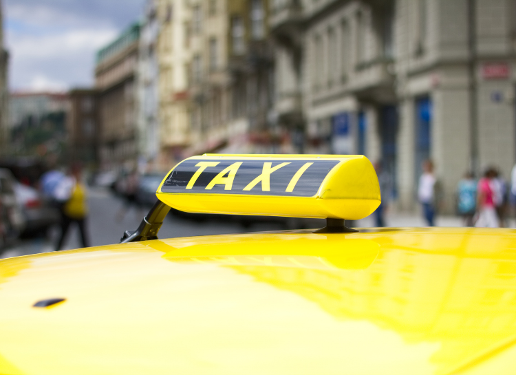Yellow Prague taxi sign on top of a taxi car in Prague city center