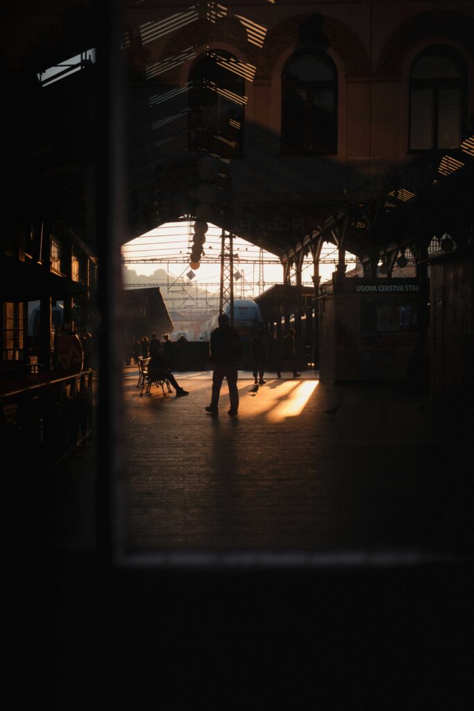 Sunset atmosphere inside Prague Main Railway Station with travelers and train platforms