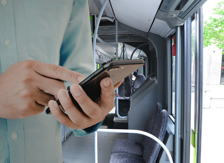 Passenger using mobile phone inside Prague tram to activate SMS ticket before boarding
