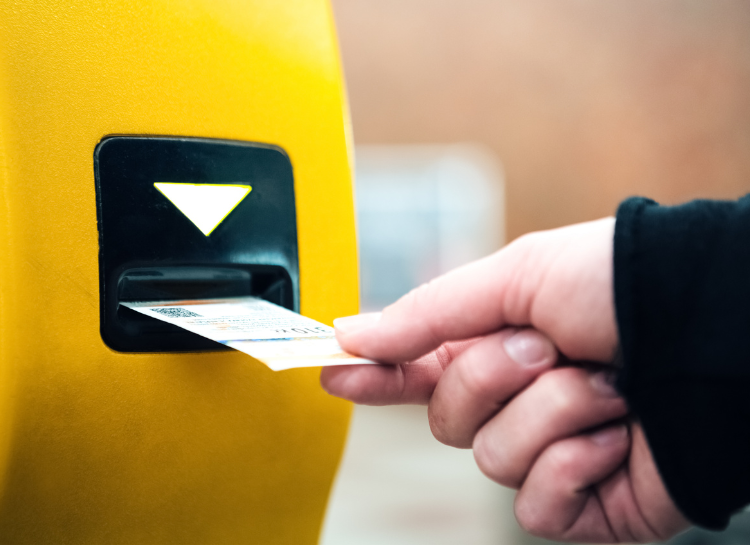 Prague tram ticket being validated in yellow validation machine to activate ticket and avoid fines