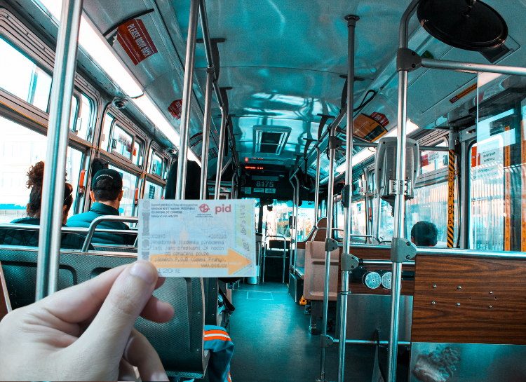 Tourist holding a Prague tram ticket inside tram showing how time-based tickets can expire mid-journey
