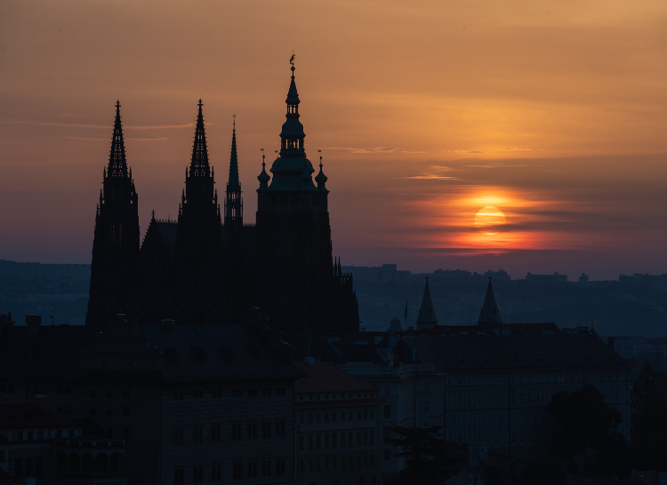 Silhouette of Prague Castle and St. Vitus Cathedral during sunset over Prague skyline, featured in a guide about the best time to visit Prague Castle without crowds, comparing peaceful early morning visits with busy midday tourist hours.