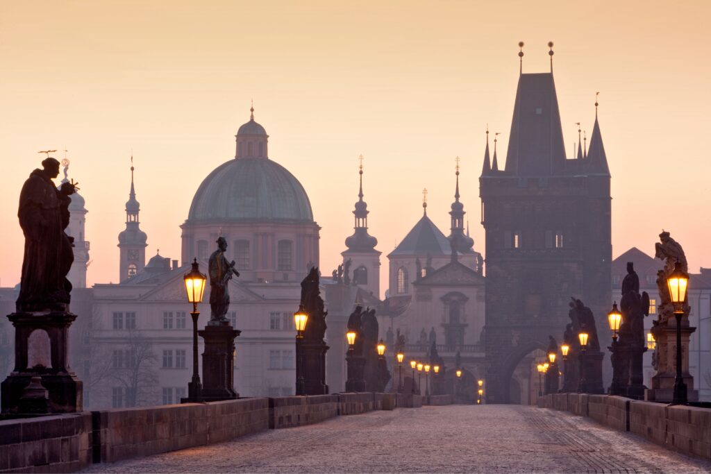 Charles Bridge Prague at sunrise facing the Old Town Bridge Tower, the iconic medieval bridge linked to legends of eggs, astrology, and one of the most fascinating dark stories in Prague