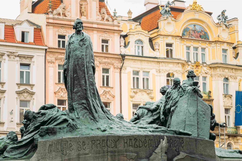 Famous People in Prague: Jan Hus Memorial in Prague's Old Town Square surrounded by historic buildings