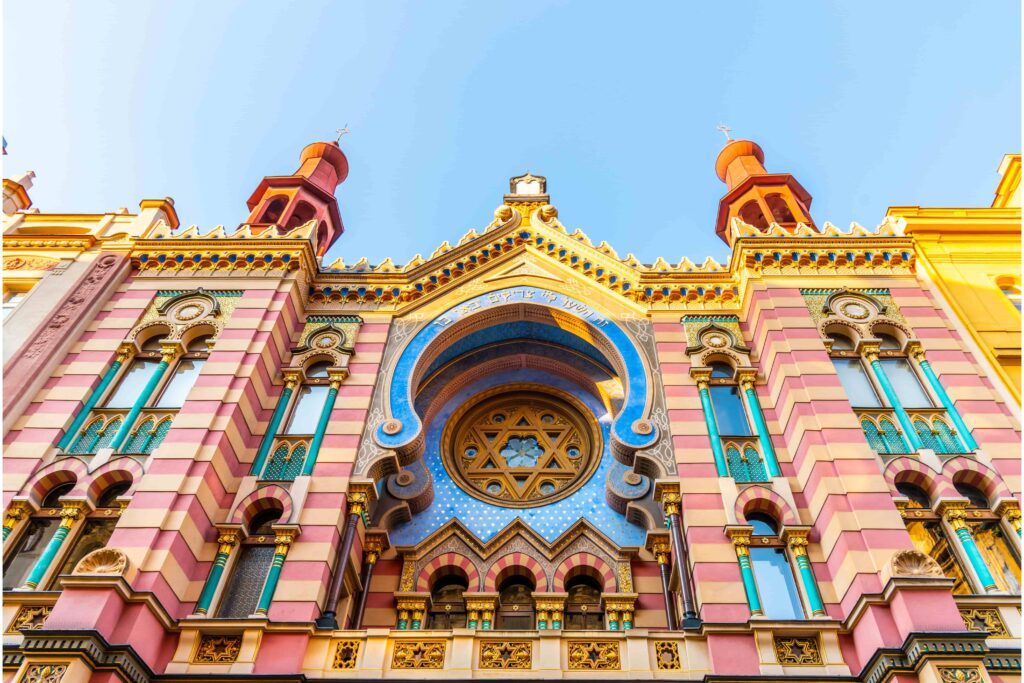 Prague Architecture – Jubilee Synagogue, a Moorish Revival and Art Nouveau landmark featuring a colorful striped façade, ornate arches, stained glass, and decorative details