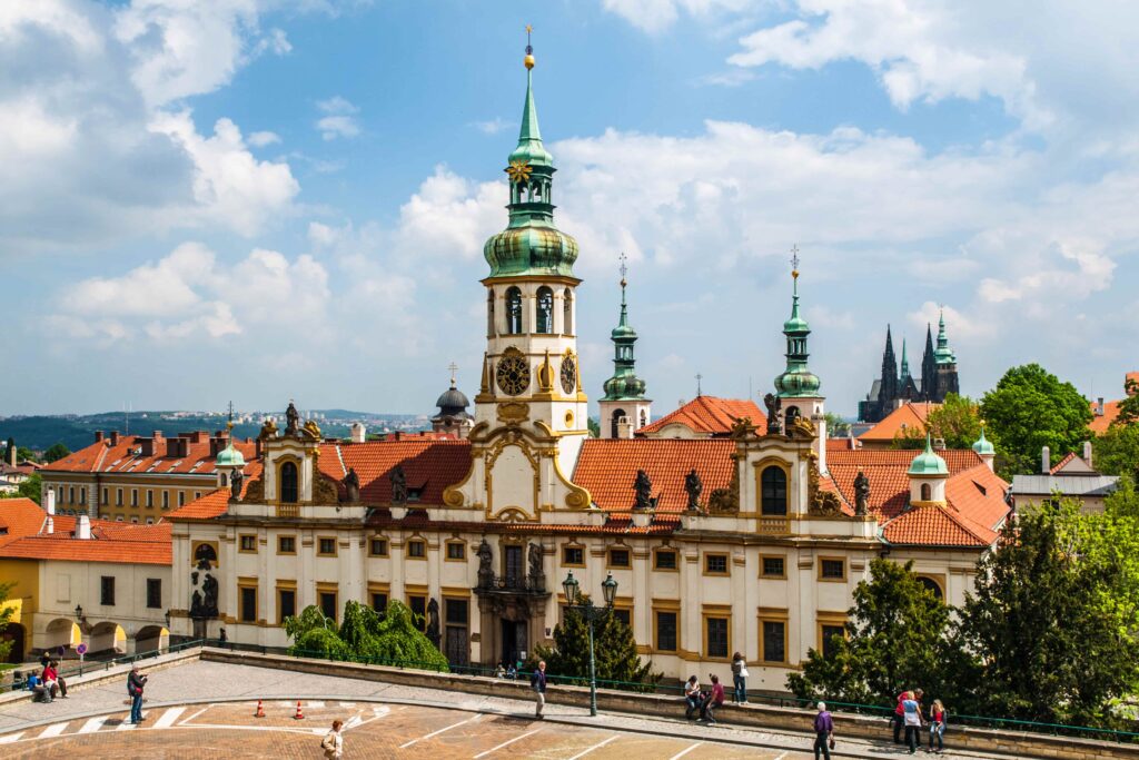 Prague Architecture – Loreto, a Baroque pilgrimage site in Prague featuring an ornate façade, elegant bell tower, and historic church complex