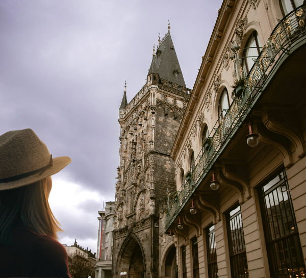 Traveler looking up at the Powder Tower, one of the most iconic Prague Towers in the Old Town