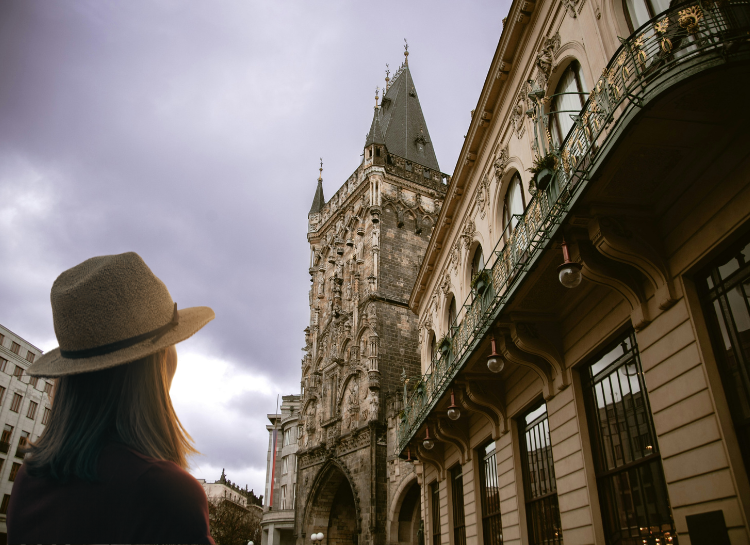 Traveler looking up at the Powder Tower, one of the most iconic Prague Towers in the Old Town