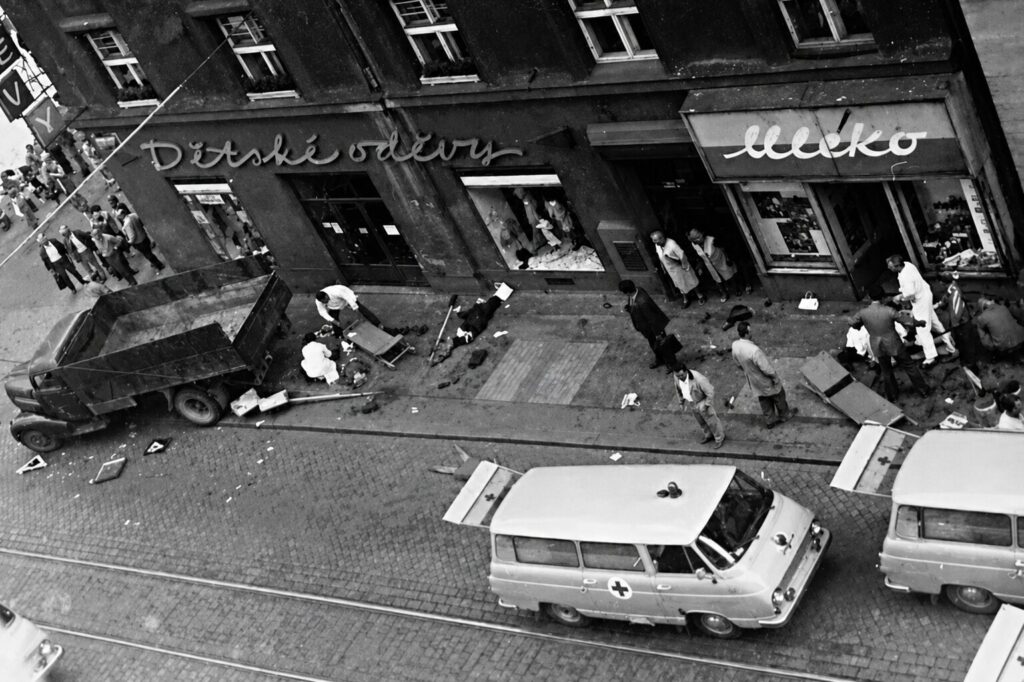 Historic photo of the aftermath of the 1973 attack at Strossmayerovo náměstí tram stop in Prague, showing emergency vehicles and rescue efforts after the deadly incident