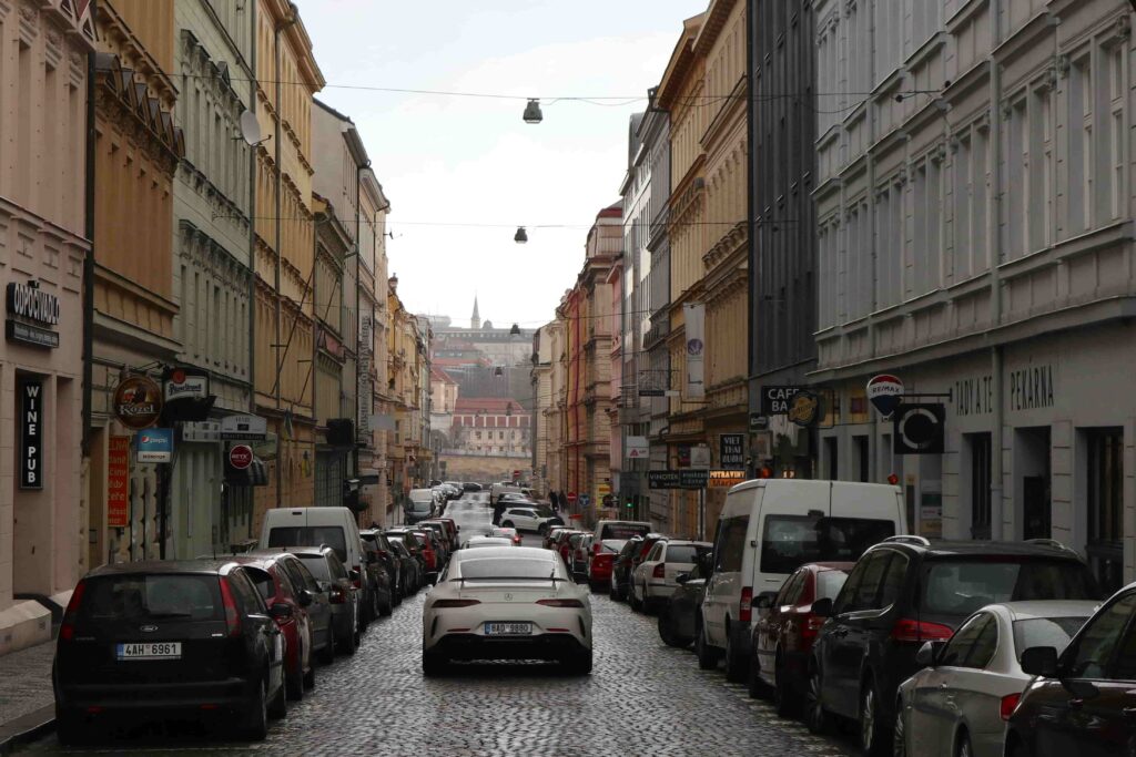 Historic Prague street lined with colorful buildings and cobblestone pavement