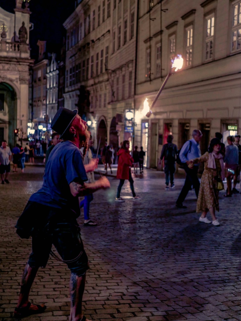 Prague Night Activities with a fire performer entertaining visitors on a historic street