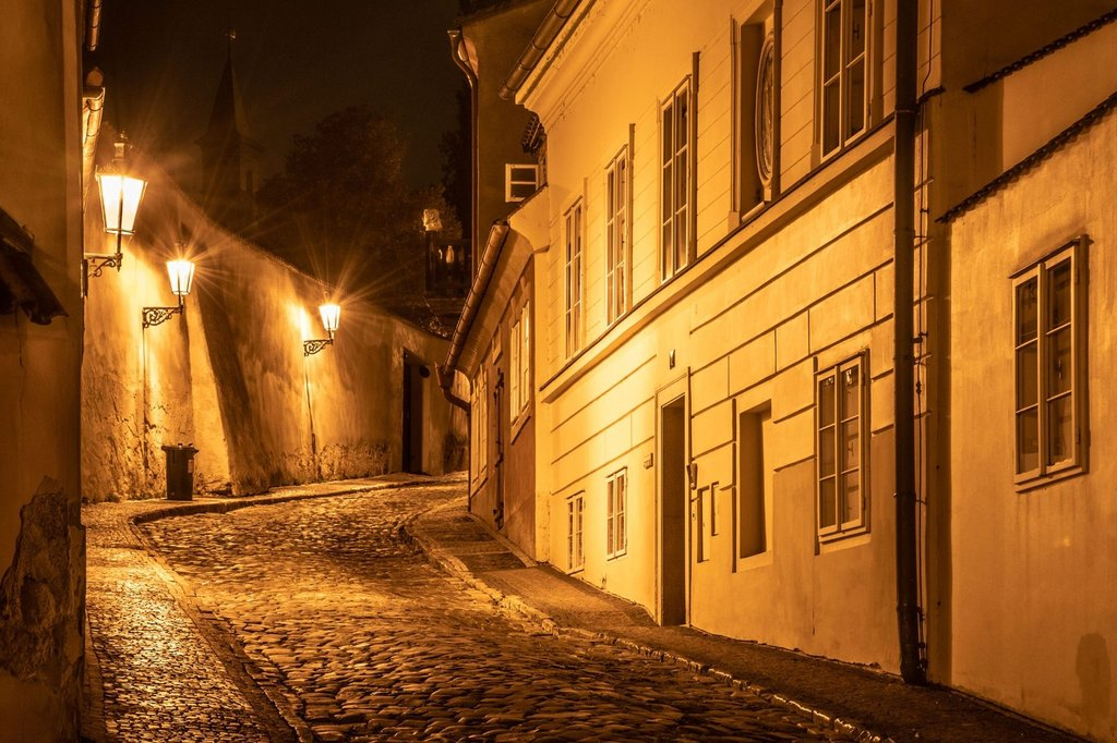 Mysterious historic Prague street at night for Prague themed walks